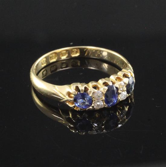 A Victorian 18ct gold, three stone sapphire and four stone diamond set ring, size N.